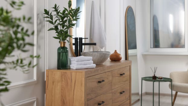 Bathroom interior with decorative vase and wooden vanity unit 