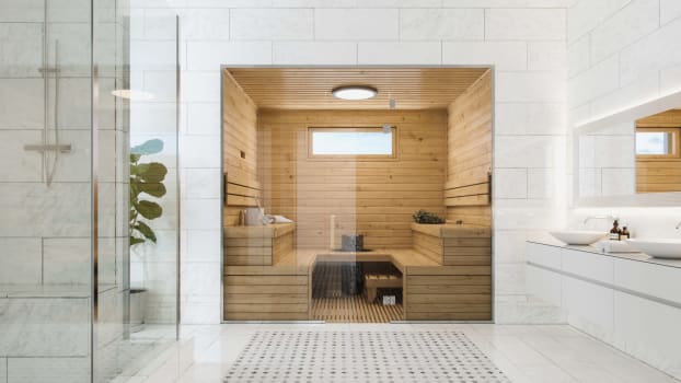 Sauna en bois derrière une vitre en verre dans une grande salle de bain