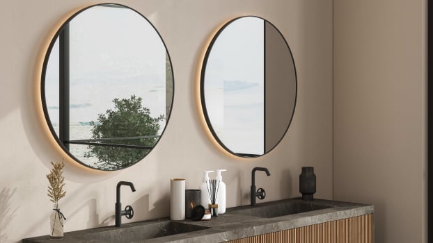 Miroirs ronds accrochés sur mur beige, vasque posée sur meuble de salle de bain en bois