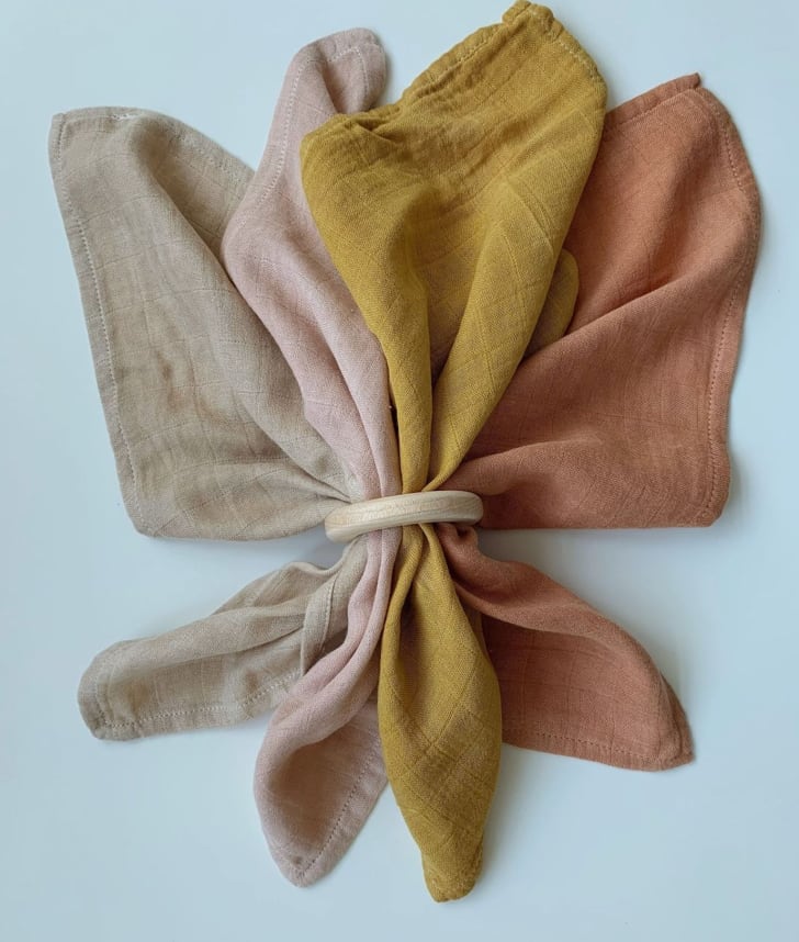 Quatre serviettes en coton teint, retenues par un anneau de bois