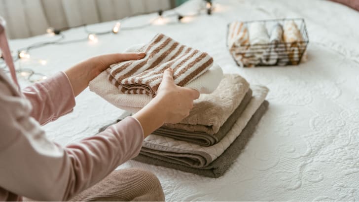 Woman folding a stack of towels