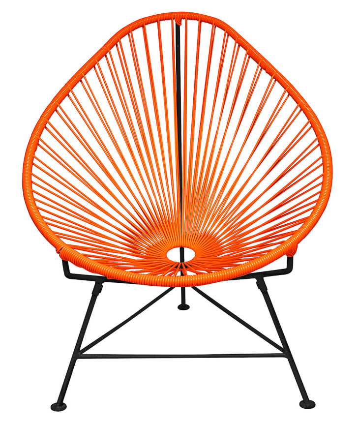 Déco voyage, chaises orange en fils de plastique, structure en métal noir