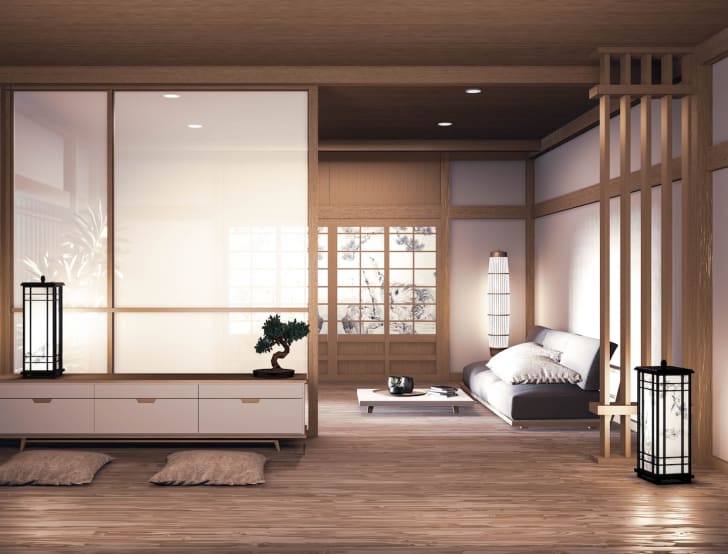 Déco voyage, salon japonais, canapé et table bas, lampes en papier au sol, écrans shoji, claustra en bois, bonsai sur commode