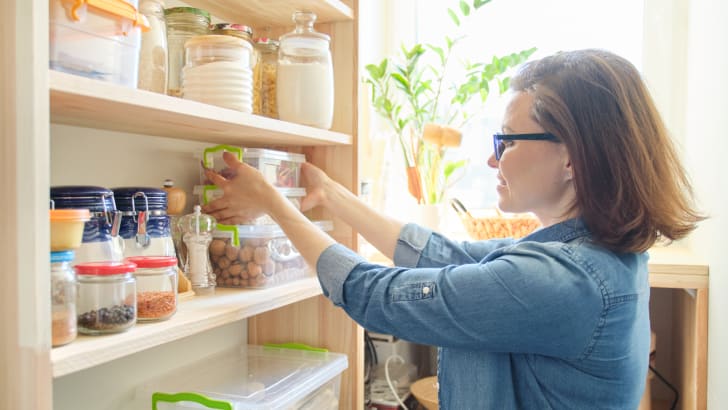 Woman looking through food supplies in pantry