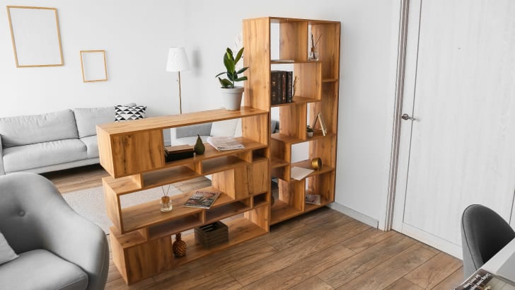 Wooden bookcase diving a room into two parts