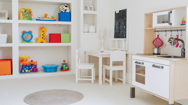 Colourful children’s toys stored on shelves in a neutral room