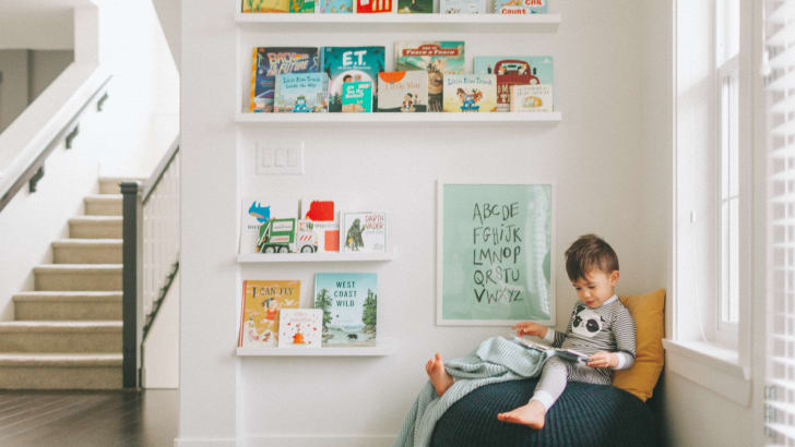 A little boy reading a book in his reading corner