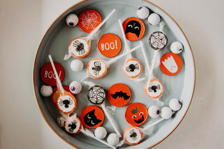 Bol d’Halloween incluant des yeux globuleux et des sucettes de couleur blanche, noire et orange    