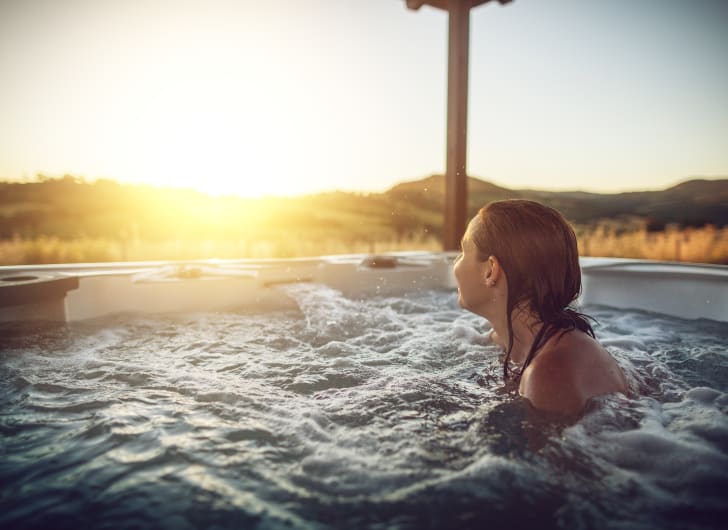 A person in a hot tub watching the sunset