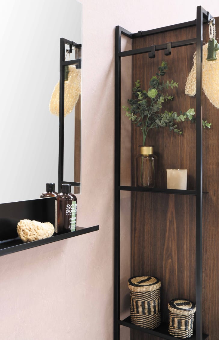 Black high shelf hanging behind a bathroom shelf with accessories on it