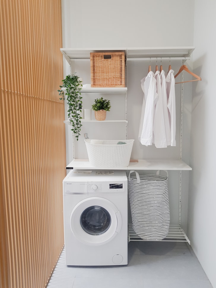Tablettes et barre de suspension pour accrocher les vêtements au-dessus d'une machine à laver dans une petite salle de lavage résidentielle