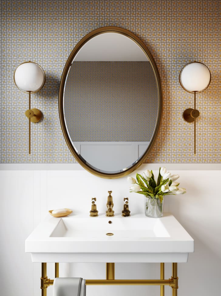 Intérieur d'une salle de bain moderne avec une mosaïque sur le mur, un miroir rond et un lavabo carré/