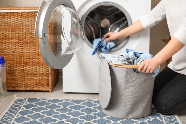 Personne remplissant une machine à laver à haute performance énergétique