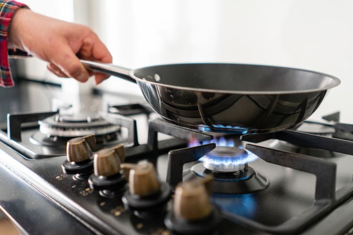 Poêle sur un brûleur à gaz naturel et plaque de cuisson sur une cuisinière 