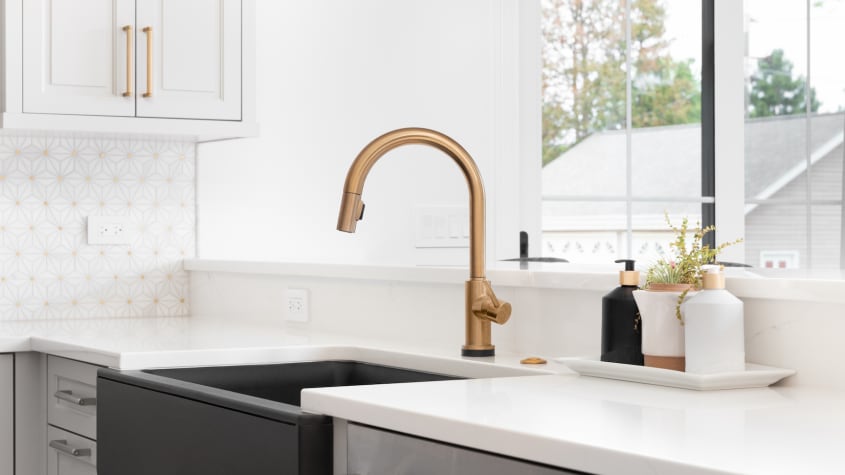 Golden faucet in a white kitchen