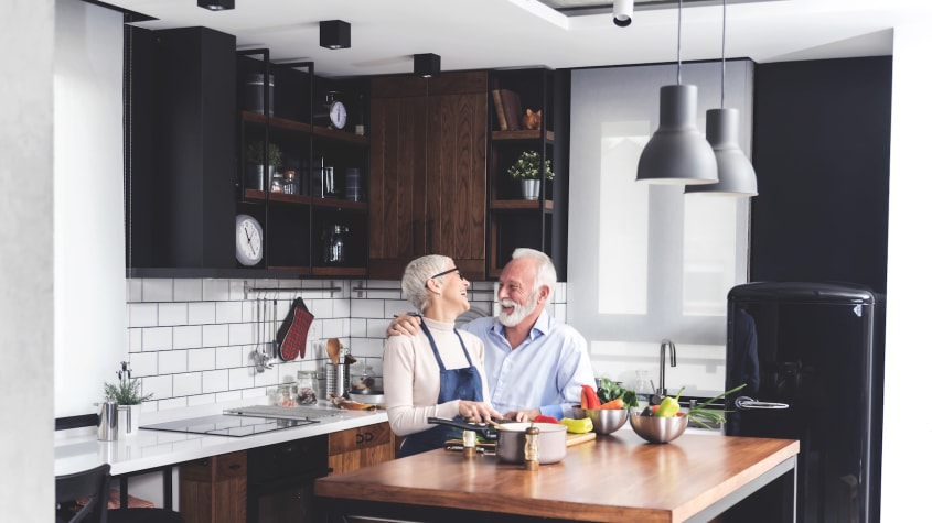 Aged couple laughing in a kitchen