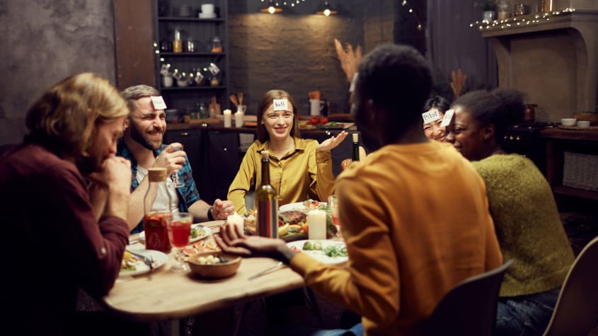 Group of friends playing a guessing game during Thanksgiving dinner