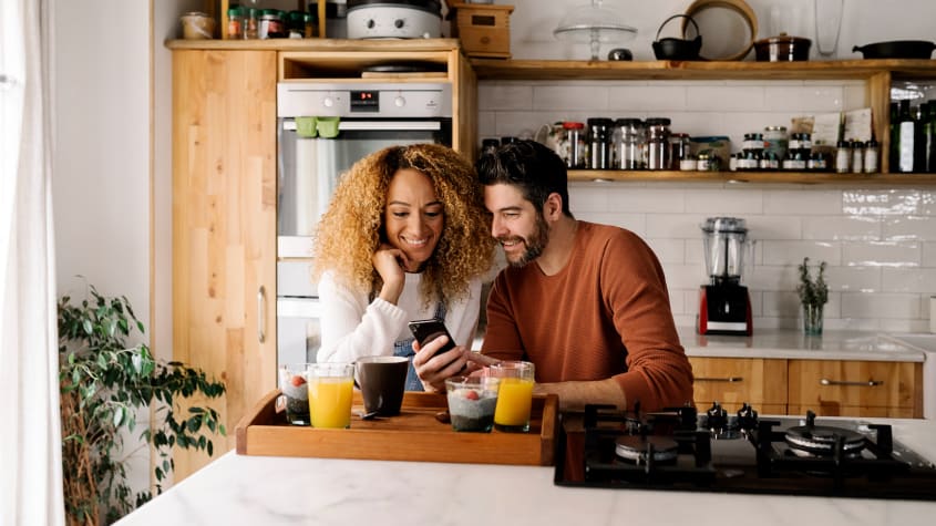 Couple laughing and drinking orange juice