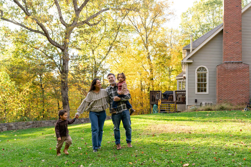 Family in front of a single-family house with a backyard