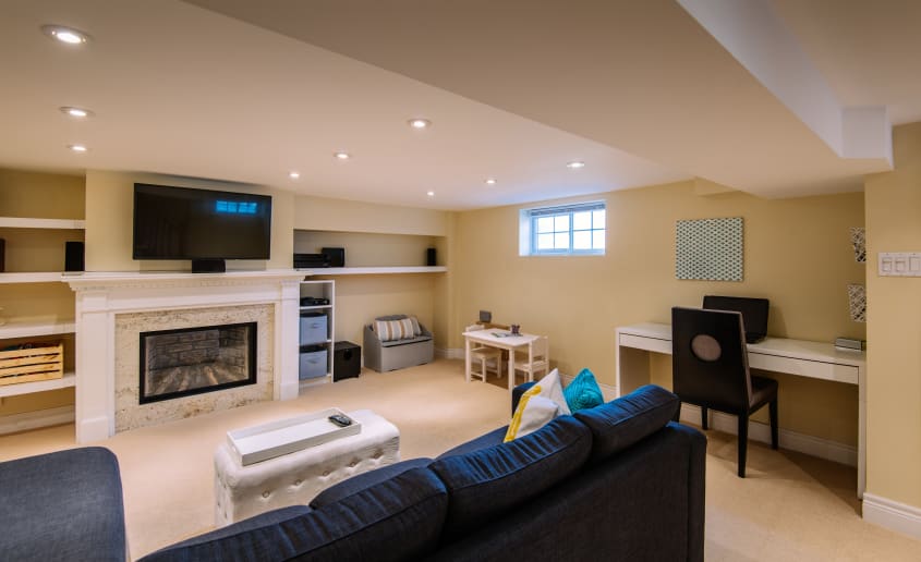 Photo of a basement finished as a versatile space (home office and lounge area, thoughtful lighting, contemporary finishes)