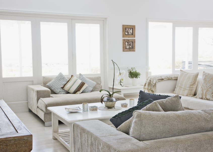 Photo of a bright, decluttered living room after home staging: neutral furniture, plants, abundant natural light.