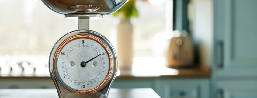 Une balance de style antique en fer et en cuivre est utilisée pour donner un style rustique chic à une cuisine moderne