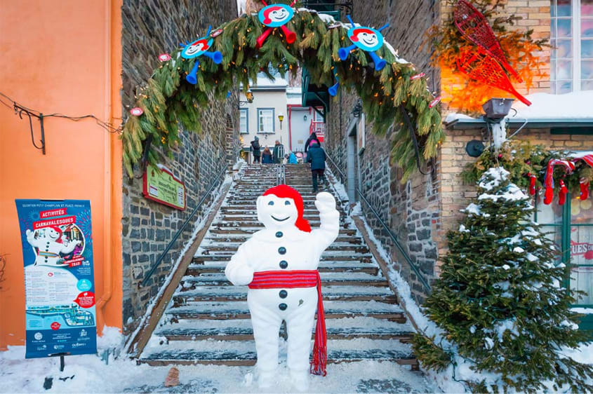 Statue du Bonhomme Carnaval de Québec devant un escalier dans le Petit-Champlain