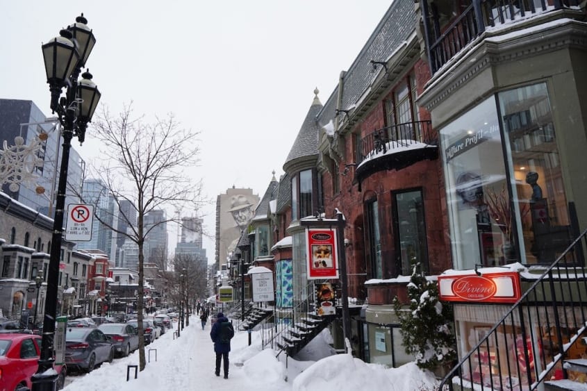 Winter scene of the sidewalk and shop windows on Crescent Street in Montréal