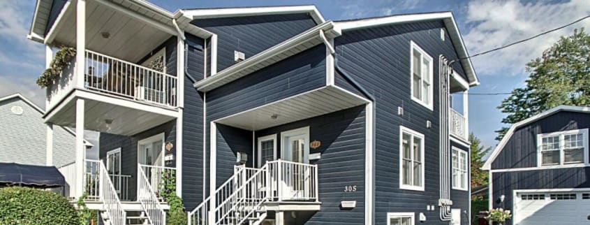 Immeuble locatif bleu avec balcon blanc