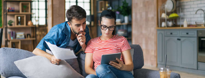 Couple thinking while looking at a tablet