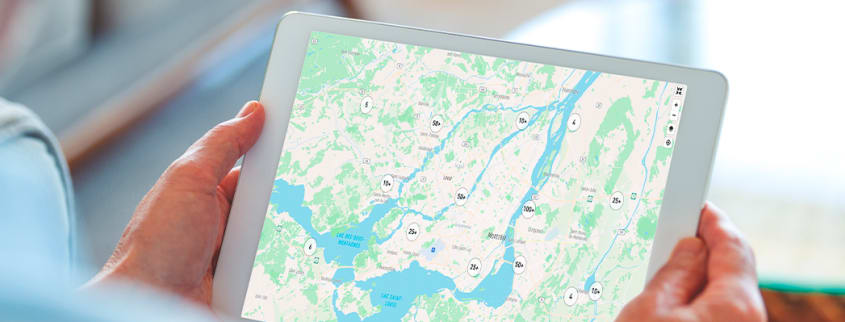 Une personne tient une tablette sur laquelle on voit une image avec les prix de vente