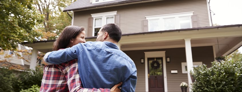 Happy couple looking at their newly sold house