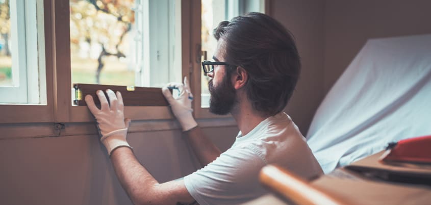 Homme installant une nouvelle fenêtre dans une maison