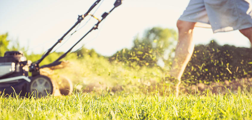 Man cutting grass in the spring
