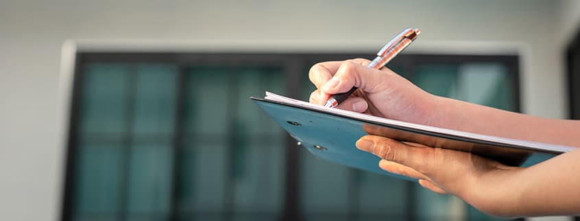 Femme prenant des notes lors de l'inspection d'une propriété