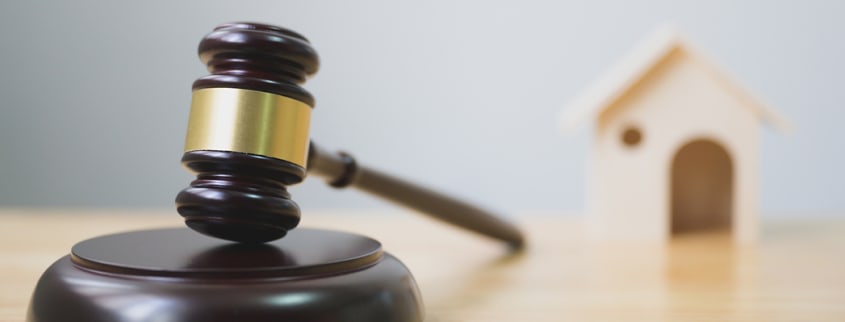 Gavel and wooden house representing a sell without legal warranty