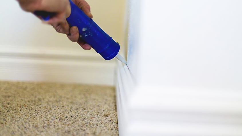 Caulking trim on wall