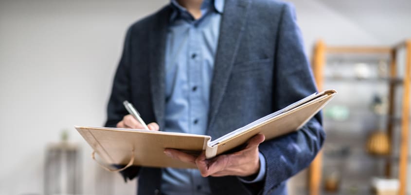 Évaluateur remplissant un rapport d'évaluation pour une maison