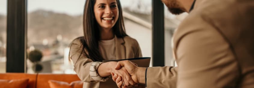 Woman smiling and shaking a man's hand