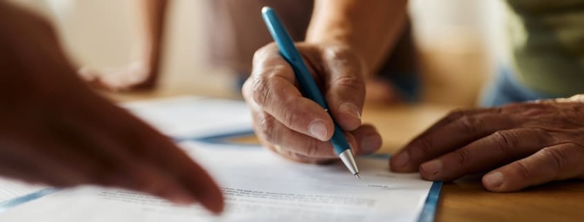 Main qui tient un style et qui signe un contrat
