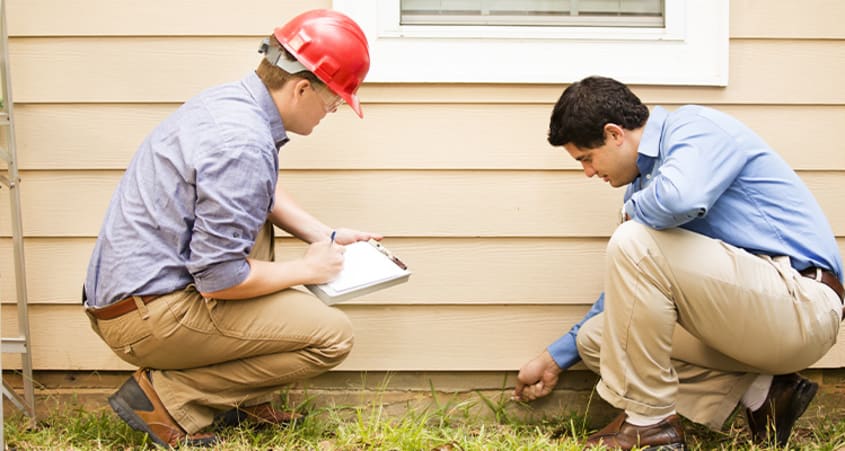 Inspectors inspecting the outside of a house