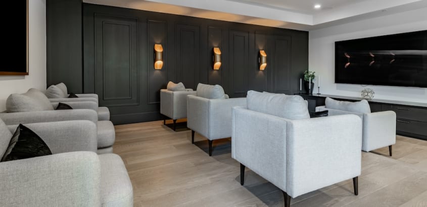  Espace commun d‘une copropriété avec sofas gris et télévision