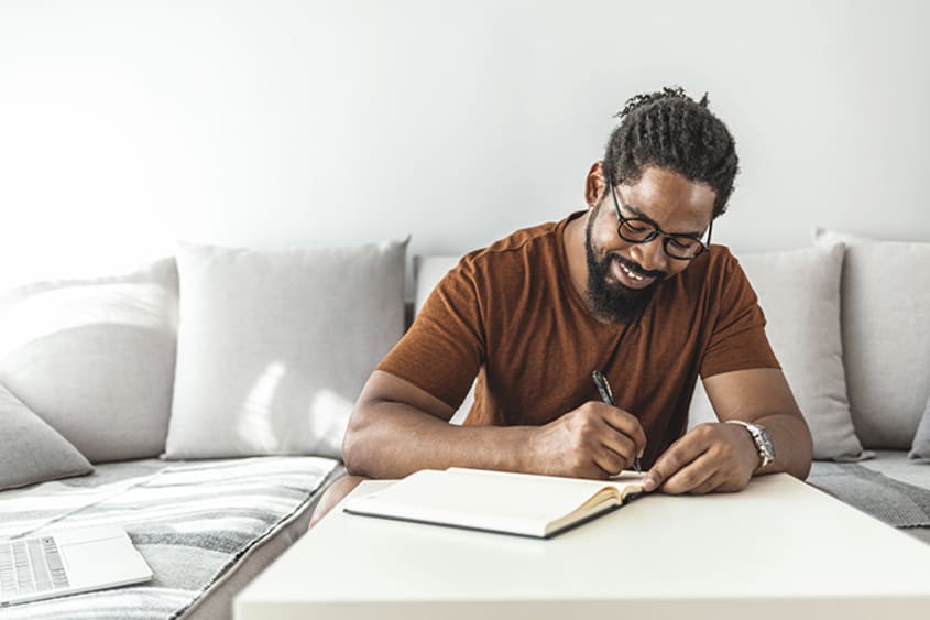 Men writing ideas in a notebook
