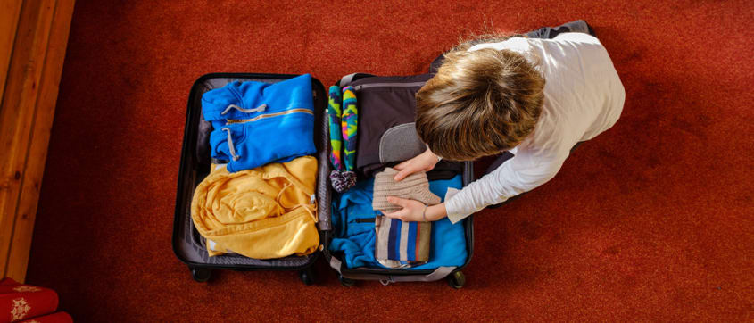 Enfant remplissant une valise de linge