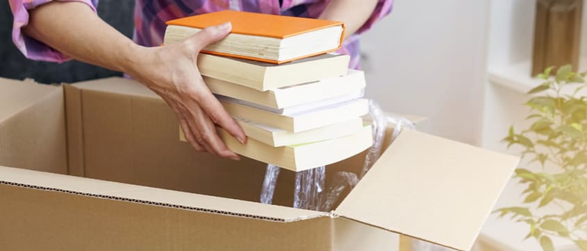 Person putting books in a moving box