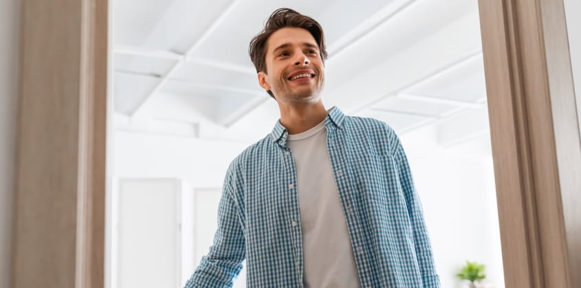 Man who opens the front door and welcomes a visitor as part of an open house