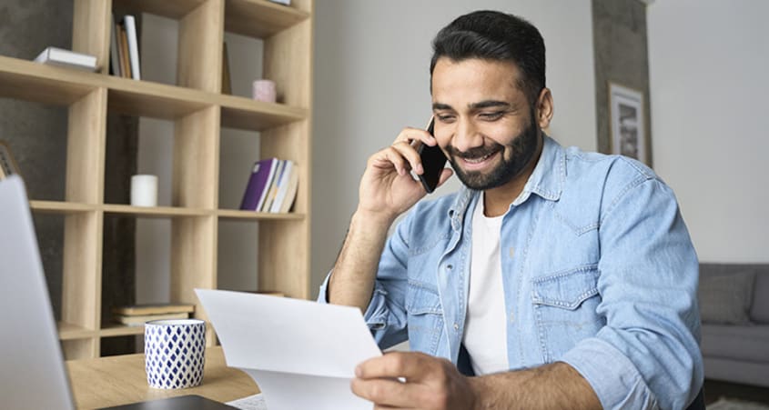 Man reading a cover letter while talking on the phone