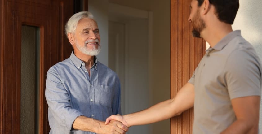 Two people shaking hands during a house visit