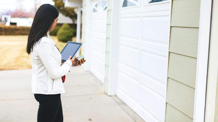 A chartered appraiser in front of a garage door