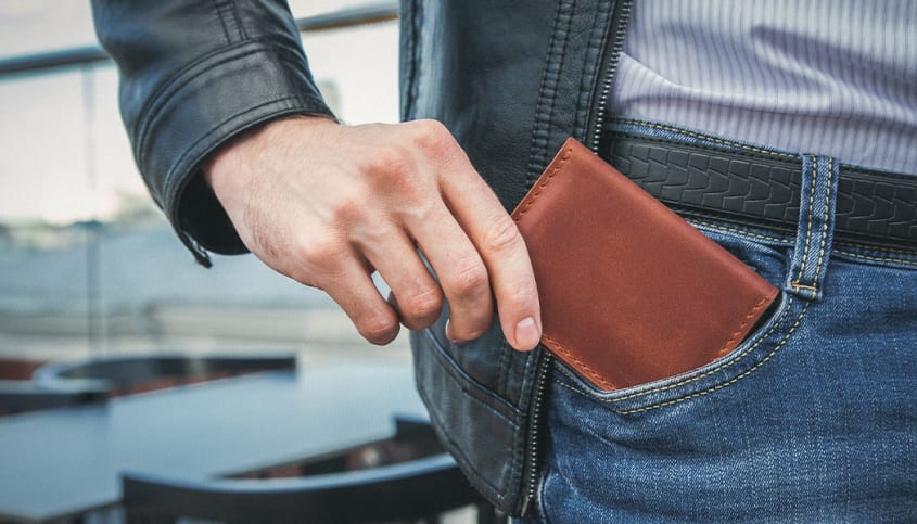 Homme sortant un portefeuille de sa poche de jeans